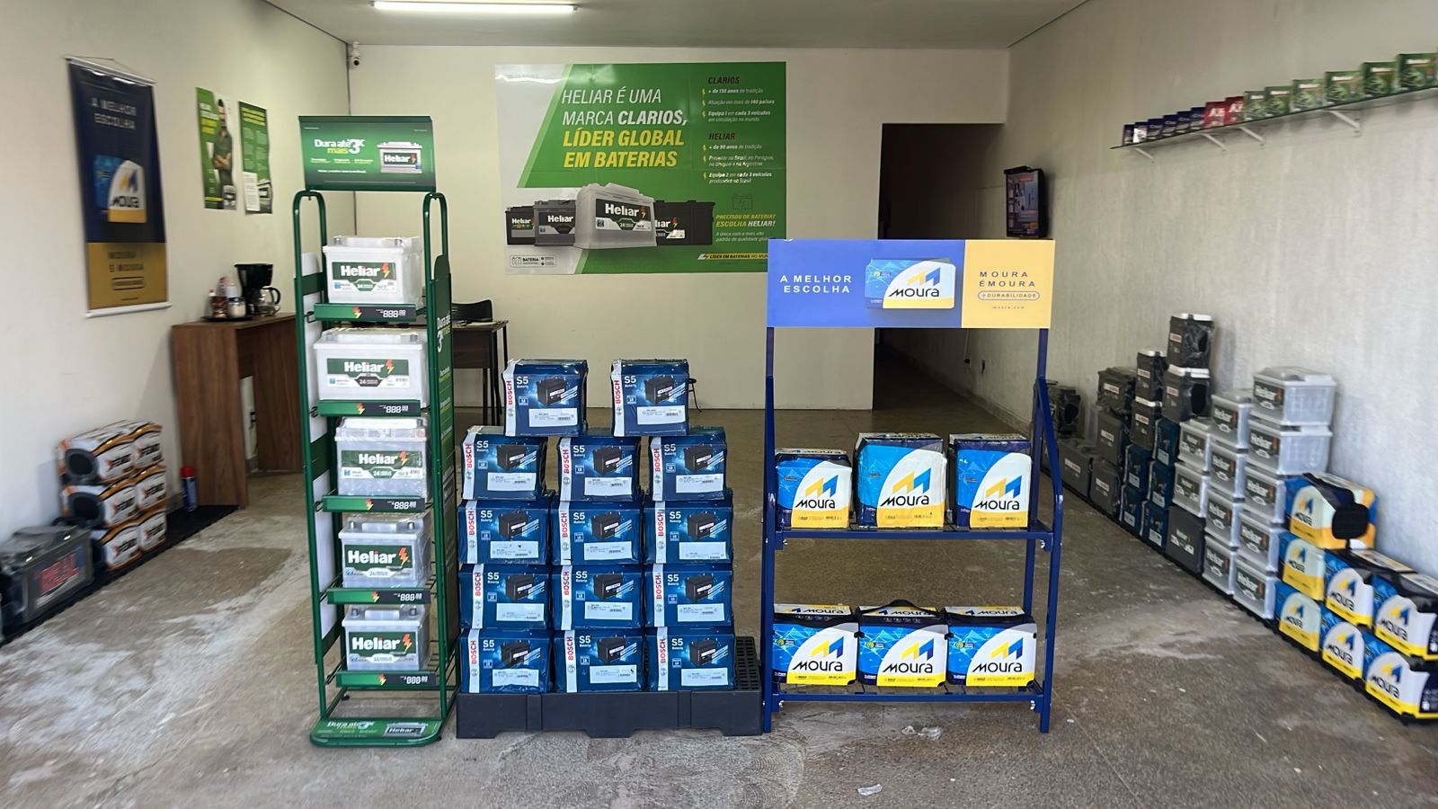 Interior da loja Baterias em Brazlândia com expositores das marcas Heliar, Bosch e Moura